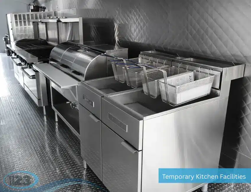 Commercial deep fryer station inside mobile kitchen trailer with stainless steel equipment and multiple fryer baskets