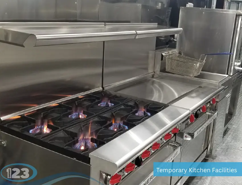 Commercial gas burner stove inside mobile kitchen trailer with blue flames and stainless steel cooking equipment